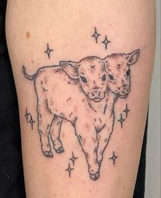 a cow and calf tattoo on the right thigh, with stars around it's legs