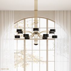 an elegant chandelier hangs from the ceiling in front of a window with sheer curtains