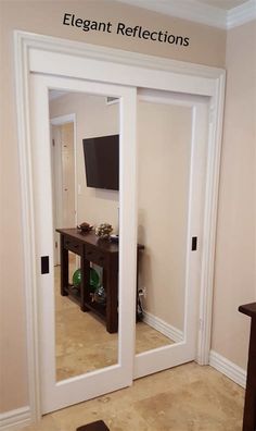 an empty room with two doors and a television mounted on the wall in it's corner