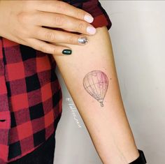 a woman with a hot air balloon tattoo on her arm