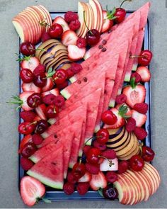 watermelon slices, strawberries and cherries arranged on a platter for a fruit tray