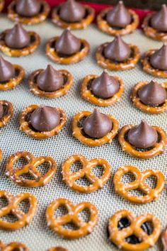 chocolate covered pretzels on a baking sheet with other pretzels in the background