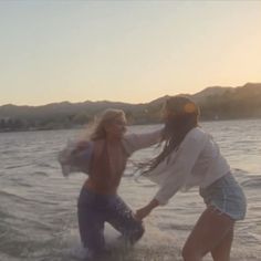 two women are playing in the water together