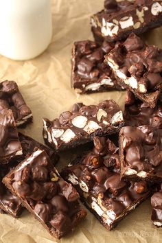 several pieces of chocolate and marshmallow brownies with a glass of milk in the background