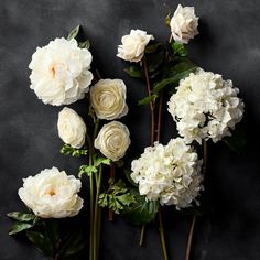 white flowers are arranged on a black surface