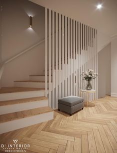 a living room with wooden floors and white railings next to a gray ottoman in front of a stair case