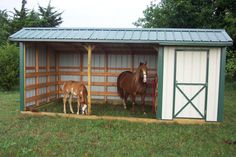 two horses are standing in a small stable