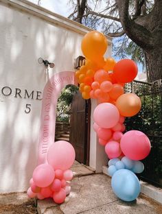 a bunch of balloons that are in front of a building