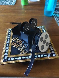 a cake made to look like a film reel and clapsticks on the table