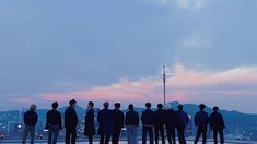 a group of people standing on top of a roof looking at the cityscape