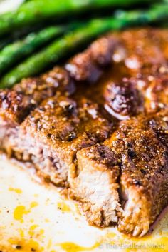 some meat and asparagus on a white plate