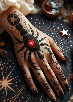 a woman's hand with black and white tattoos on it, next to some stars