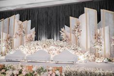 an elaborate stage set up with flowers and white linens for a wedding ceremony or reception