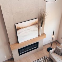 a living room filled with furniture and a painting on top of a fireplace mantel