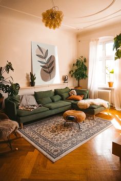 a living room with green couches and rugs in front of a large window