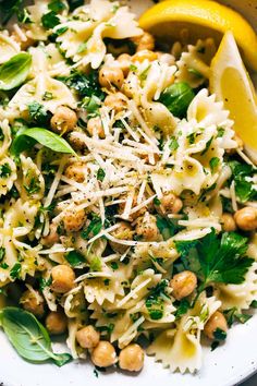 a white bowl filled with pasta, spinach and chickpeas