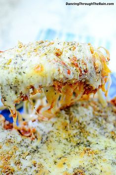 a slice of lasagna being lifted from a casserole dish with cheese and sauce