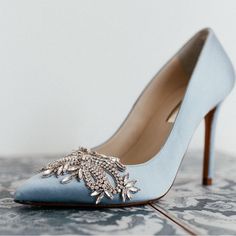 a pair of blue high heel shoes on top of a table