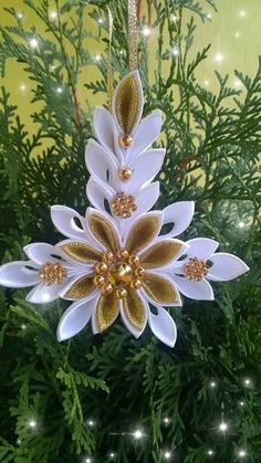 a white and gold ornament hanging from a tree