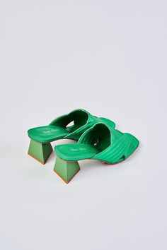 Ultra-chic, ultra-comfortable, introducing our Stella Satin Mule. Crafted from satin in brilliant metallic Green, this shoe features a trendy triangular shaped heel in a tonal shade of green. We love the chic cut-out crossover design and square-shaped peep toe. Complete your look with this bold pop of colour. Modern Green Heels For Summer, Green Spring Heels With Padded Heel, Spring Green Heels With Padded Heel, Green Heels With Padded Heel For Spring, Modern Green Heels With Wrapped Heel, Trendy Green Heels With Sculpted Heel, Modern Green Open Heel Heels, Green Sandals With Padded Heel, Green Pointed Toe Sandals With Removable Insole