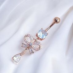 Super cute y2k 2000s rose gold diamond rhinestone ribbon bow heart dangling belly piercing ring bar.  Surgical steel  FREE STANDARD UK SHIPPING Dainty Metal Body Jewelry As Gift, Trendy Rose Gold Cubic Zirconia Jewelry, Dangle Metal Belly Rings, Dangle Body Jewelry For Gifts, Elegant Metal Dangle Belly Rings, Dangle Belly Rings For Wedding, Trendy Metal Body Jewelry For Gifts, Trendy Bling Jewelry As A Gift, Dangle Cubic Zirconia Body Jewelry As A Gift