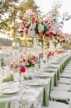 a long table is set with flowers and plates