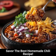 a spoon full of chili and cheese being lifted from a bowl with the words savor the best homemade chili recipe