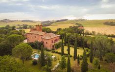 an aerial view of a large house surrounded by trees and bushes with a pool in the middle