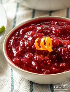 a white bowl filled with cranberry sauce on top of a blue and white table cloth