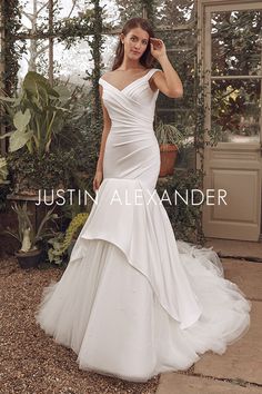 a woman in a white wedding dress posing for the camera