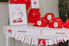 a table topped with lots of red bags and decorations on top of a white table