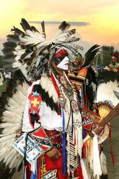 a native american man dressed in costume with feathers