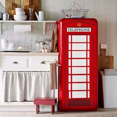 a red phone booth sitting in the middle of a kitchen