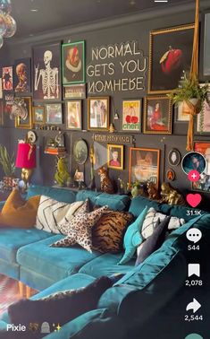 a living room filled with blue couches and lots of pictures on the wall above them