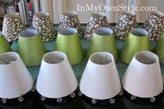 several green and white lamps are lined up on a table