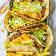 three tacos filled with meat, cheese and lettuce