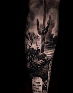 a man's arm with a cactus on it and a sign in the middle