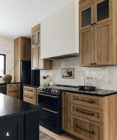 a kitchen with wooden cabinets and black counter tops, an oven and stove top in the center