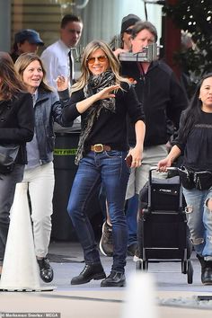 the woman is walking down the street with her luggage and two other people behind her