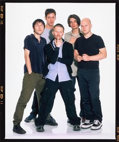 a group of young men standing next to each other in front of a white background