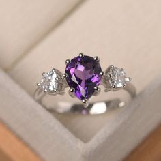 This ring features a 7*9mm pear cut natural amethyst . Customization is available. It is made by hand, and it will take about 7 days to finish the ring after your payment is completed. Main stone: 7*9mm pear cut natural amethyst Main stone weight: 1.79 ct Metal type: 925 silver Accent stone: cz Customization is available, just fee free to contact me, it is free to engrave inside the ring, it is free, you can leave a ntoe with your order, but it will be great no more than 13 letter. Any question, Blush Pink Nails, Three Stone Ring, February Birthstone, Cute Rings, Three Stone Rings, Dream Ring, February Birth Stone, Purple Aesthetic, Silver Accents