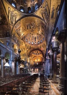 the interior of an old church with many tables and chairs in it, all lit up at night