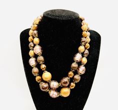 Gorgeous Vintage Signed VENDOME Double Strand Venetian Foil Glass Beaded Necklace. Chunky Venetian foiled glass beads with bronze and chocolate colored faux pearls. Signed on hook. In excellent vintage condition with minimal age appropriate wear. Shortest strand measures 18 inches long with extender and longest strand is 19 1/2 inches long with the extender. The largest beads are over 5/8 inch across. Ornate hook clasp. Stringing secure. Vintage Brown Double Strand Necklaces, Vendome Jewelry, Vintage Gold-tone Multi-strand Necklaces, Vintage Multi-strand Necklace With Faceted Beads, Vintage Bronze Multi-strand Jewelry, Vintage Multi-strand Metal Necklace, Vintage Designer Jewelry, Chocolate Color, Star Bracelet