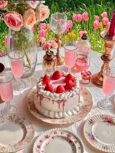 there is a cake with strawberries on it and pink flowers in the vases