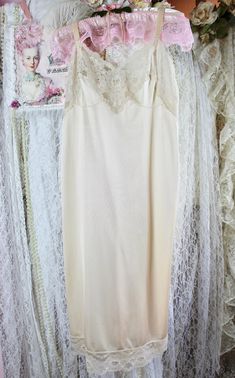 Gorgeous Vintage 70s ivory silky midi slip with wide adjustable straps and floral lace trims in great vintage condition. Pre Loved Great Condition No Stains, Snags or Fade Vintage 70s Brand: Komar Made in the USA Ivory Silky Midi Slip Intimates & sleepwear Adjustable wide satin straps Floral lace front and bottom trims Silky feeling to the touch. Material: 100% Nylon Size Approx. Medium-Large Midi length Check the measurements below for a better fit. Measured laying flat. Adjustable Straps: 17" Armpit to Armpit: 17" Across Waist: 32"- 34" Stretched Around Hips: 36"- 38" Around Length: 47" Shipping from 3-5 Days No Returns or Exchanges Thank you for Visiting Vintage Lace Trim Slip Dress For Wedding, Vintage Cream Lace Slip Dress, Vintage Cream Slip Dress With Lace Trim, Cream Lace Trim Slip Dress For Wedding, Cream Lace Slip Dress, Length Check, Lace Trims, Lace Slip, Vintage Lingerie