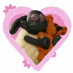 a heart shaped frame with a stuffed animal and teddy bear in the shape of a heart