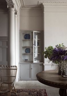 an image of a dining room with flowers in the vase on the table and chairs