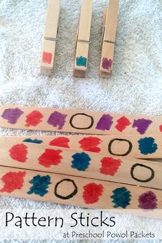 three wooden pegs with different colored shapes on them