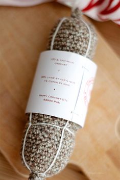 a ball of yarn wrapped in twine on top of a wooden table next to a candy cane