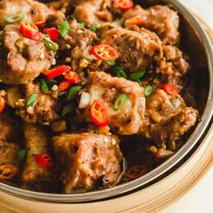 a bowl filled with meat and vegetables on top of a table